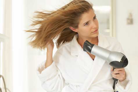 mujer secándose el pelo con el secador 