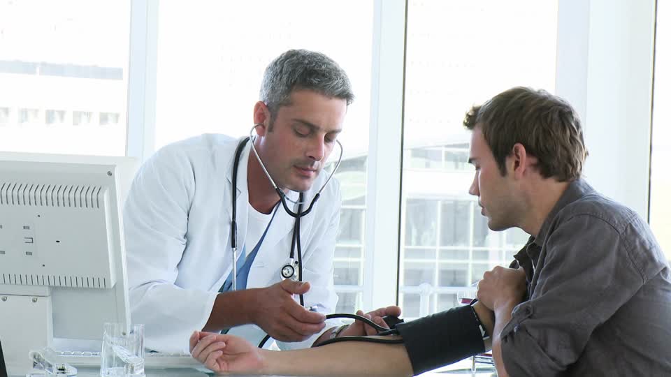 médico midiendo la presión arterial de un paciente