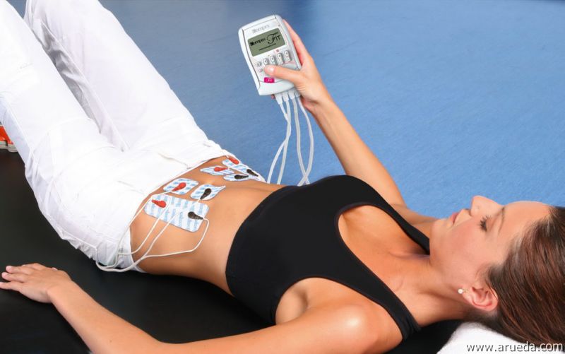 Mujer utilizando el electroestimulador en el abdomen