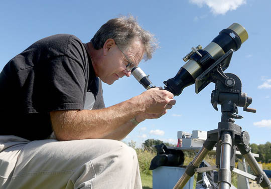 hombre mirando el cielo con un telescopio 