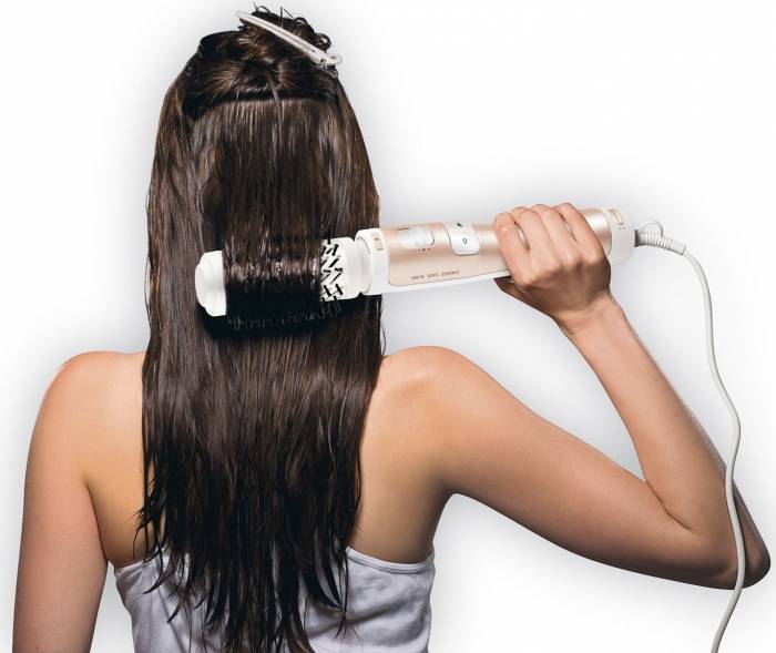 mujer secándose el pelo con un cepillo rotativo 