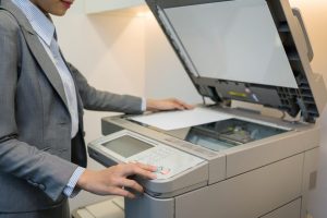 mujer usando una fotocopiadora en la oficina