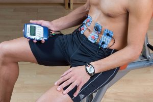 hombre utilizando electroestimuladores en los abdominales