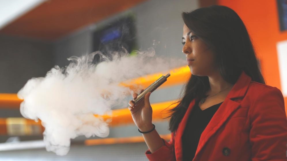 mujer utilizando un cigarrillo electrónico sin nicotina 